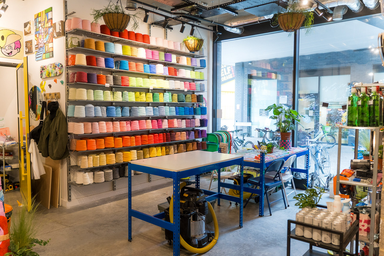 Cheeky Studio workspace in Hackney Wick with tables and colourful yarn shelves